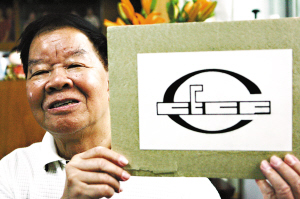 梁炯与他设计的广交会会徽.