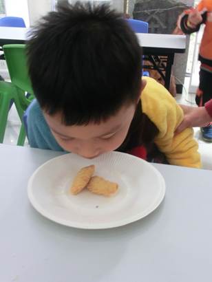 说明: 2017.1.14 越秀区图书馆开展“听·阅读——喜迎元春 同包油角”活动,图为读者闻着自己做的油角满足的样子。