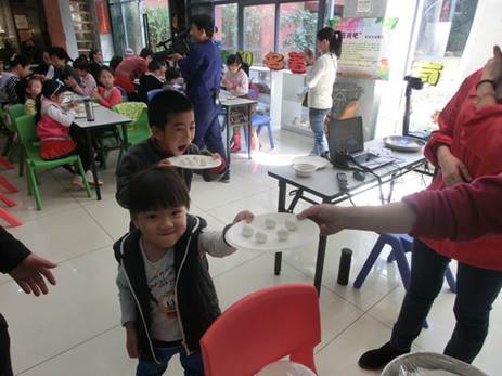 说明: C:\Users\LLM\Desktop\已调整\2017.2.21  越秀区图书馆开展“国学苑——元宵印象·火树银花合”活动，图为读者将做好汤圆给工作人员煮。.JPG