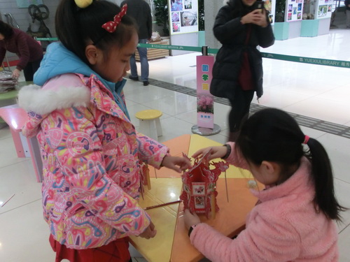 说明: D:\林遥芝\1、活动包\2017年\2017.2.25 万花筒——逛广府庙会 想享花样“年”华\已调整\2017.2.28 越秀区图书馆开展“万花筒——逛广府庙会 想花样年华”活动,图为小读者相互帮忙,协同制作花灯。.JPG