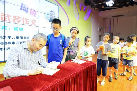 说明: C:\Users\panying\Desktop\0817\20180812广州少年儿童图书馆举办名作家见面会\周锐老师为小读者们签名.jpg