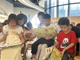 说明: 图4:陈老师跟大家玩起了“按图索骥”的游戏,要求以亲子家庭为单位找出绘本中41个故事人物,使图文对应。家长和孩子们正在亲子共读、热烈讨论。