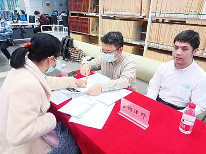 2023年3月5日法律专题角现场，视障实习律师盘铭径（右一）在提供公益服务